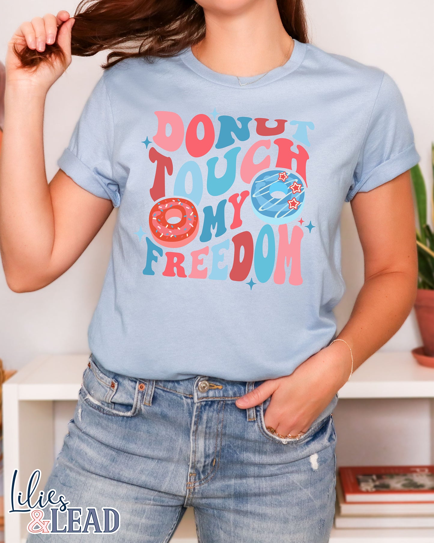 Baby blue tee with Donut Touch My Freedom printed in red, white, and blue with donut graphics.