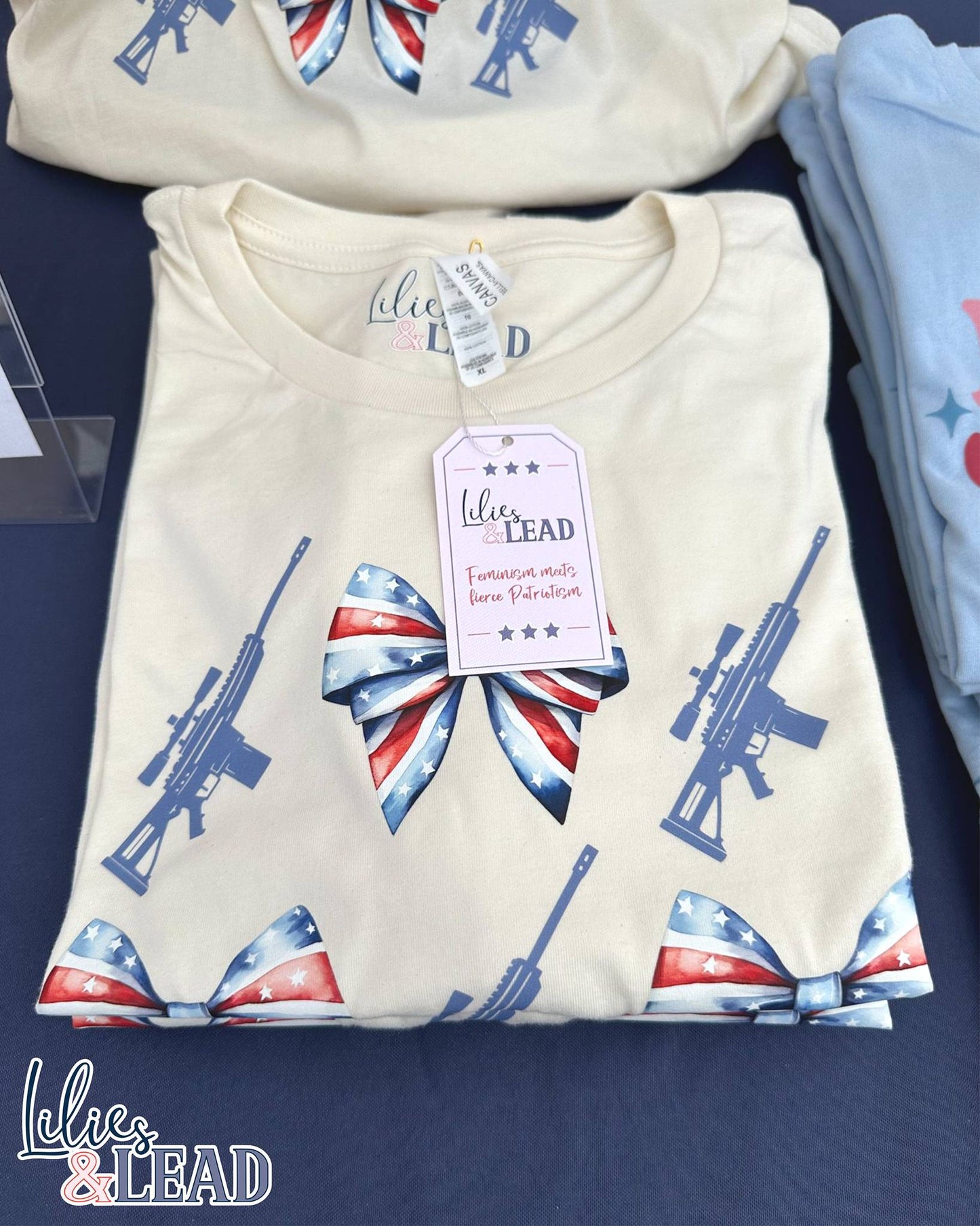 Tee shirt with patriotic bows and rifle detail folded