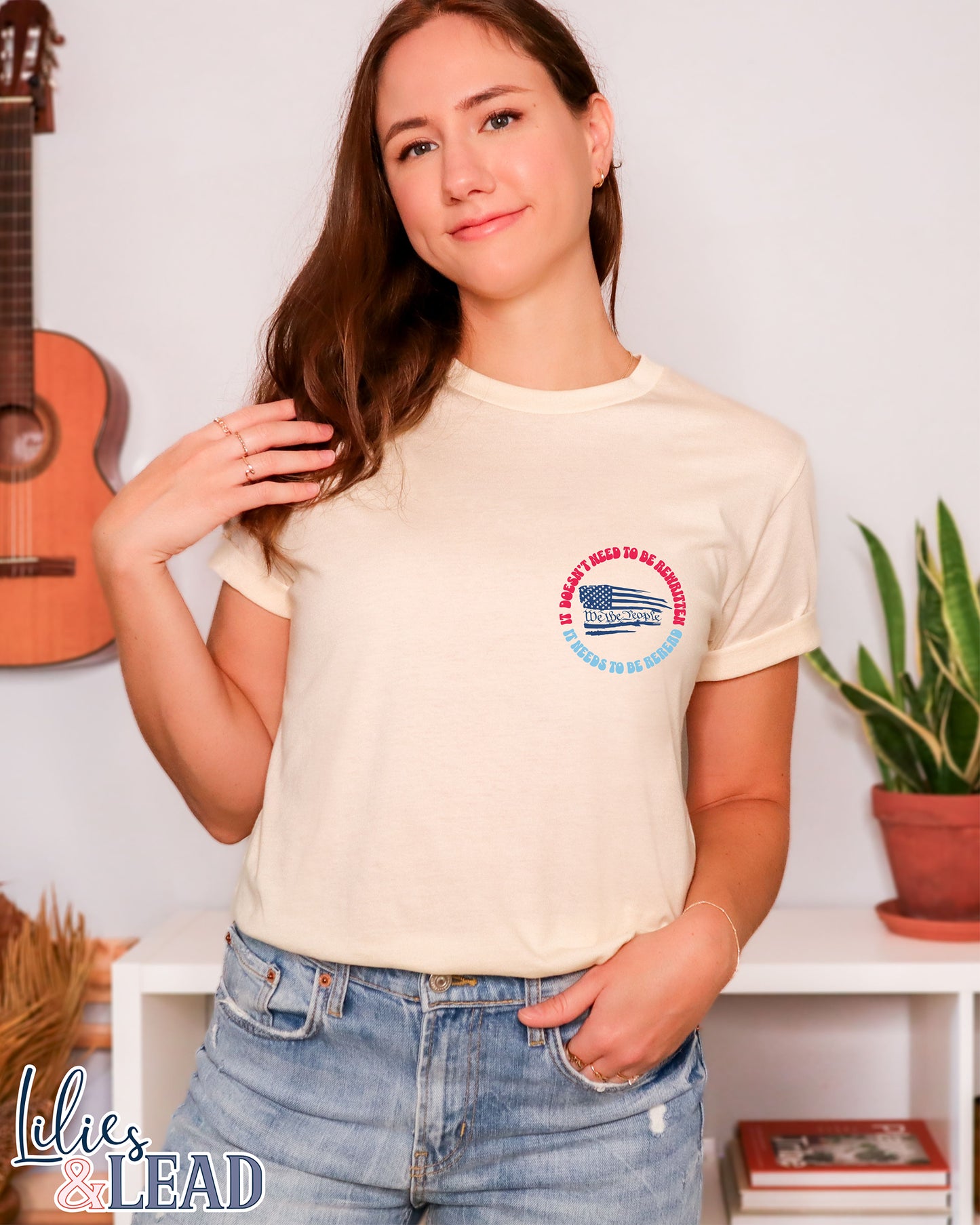 Short Sleeve Natural colored tee with the phrase It Doesn't need to be rewritten, it needs to be reread phrase in a retro font with Red, White, and blue and an American flag with We the People.
