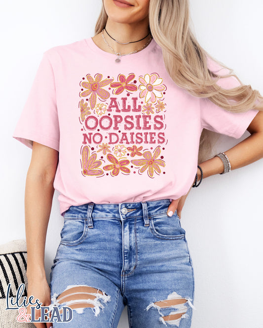 Light pink tee with saying All Oopsies No Daisies surrounded by florals in pink and white