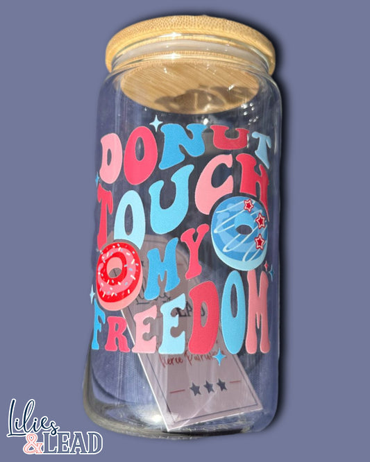 16oz glass can with retro font saying "donut touch my freedom" featuring donut graphics in variations of red, white and blue.