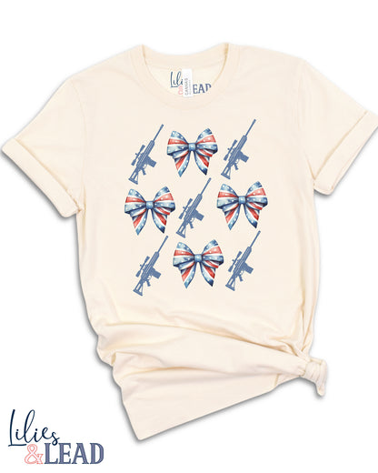 Tee shirt flatlay with patriotic bows and rifle detail 