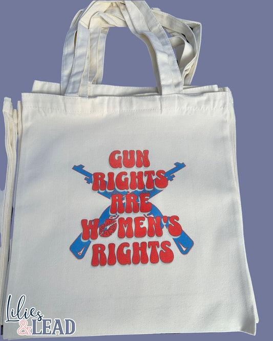 Canvas tote bag with Gun Rights Are Womens Rights in retro font, red and white. With Blue Rifles crossed in background