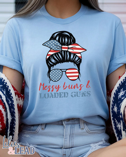 light blue tee shirt  on model with messy buns design wearing patriotic bandana and sunglasses featuring the phrase Messy buns and loaded guns 