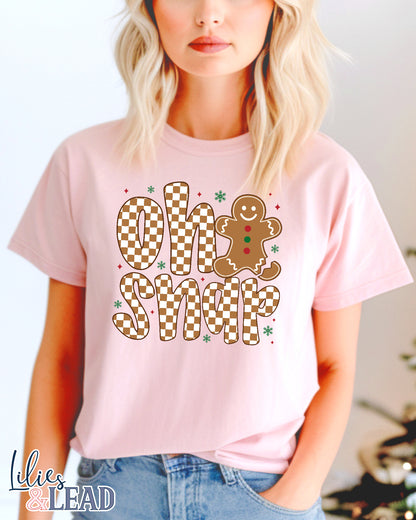 Person wearing a pink t-shirt with a gingerbread man design and "Oh Snap".