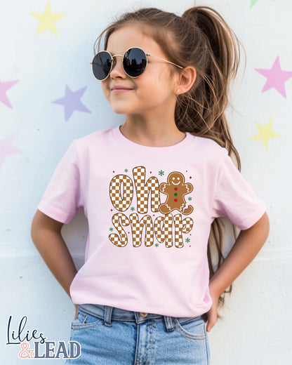 Child wearing a pink t-shirt with 'Oh Snap' design, standing against a star-patterned background.