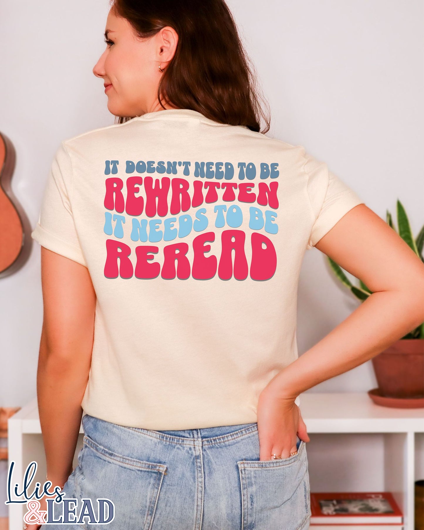 Short Sleeve Natural colored tee with the phrase It Doesn't need to be rewritten, it needs to be reread phrase in a retro font with Red, White, and blue